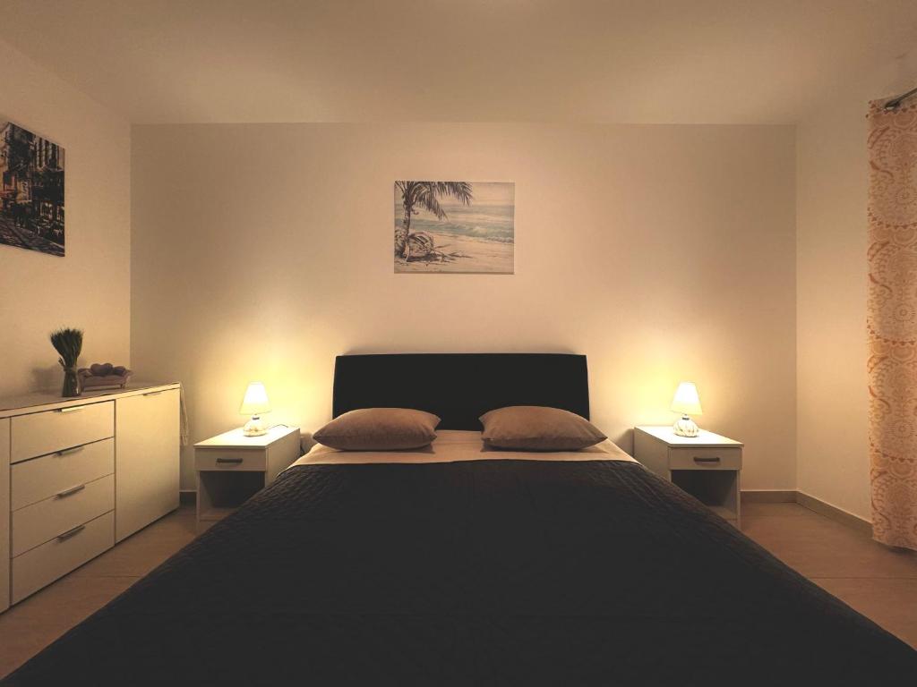 - une chambre avec un lit, 2 tables de nuit et 2 lampes dans l'établissement Friends 2 Apartments, à Risan