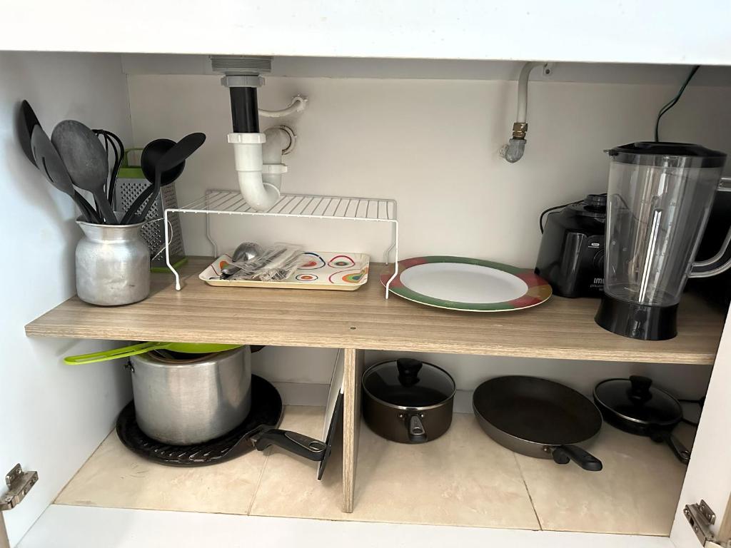 a kitchen shelf with some utensils on it at Hermoso Apartamento cerca del centro comercial jardin plaza in Cúcuta