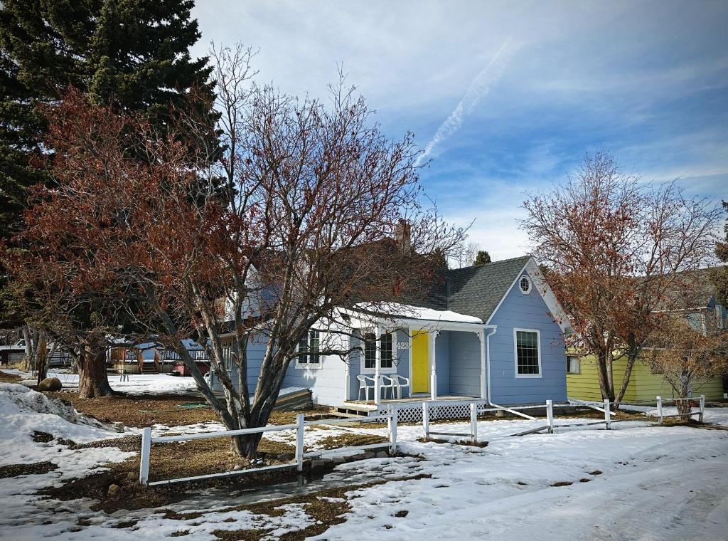 een blauw en geel huis in de sneeuw bij Red Lodge Town Cottage in Red Lodge