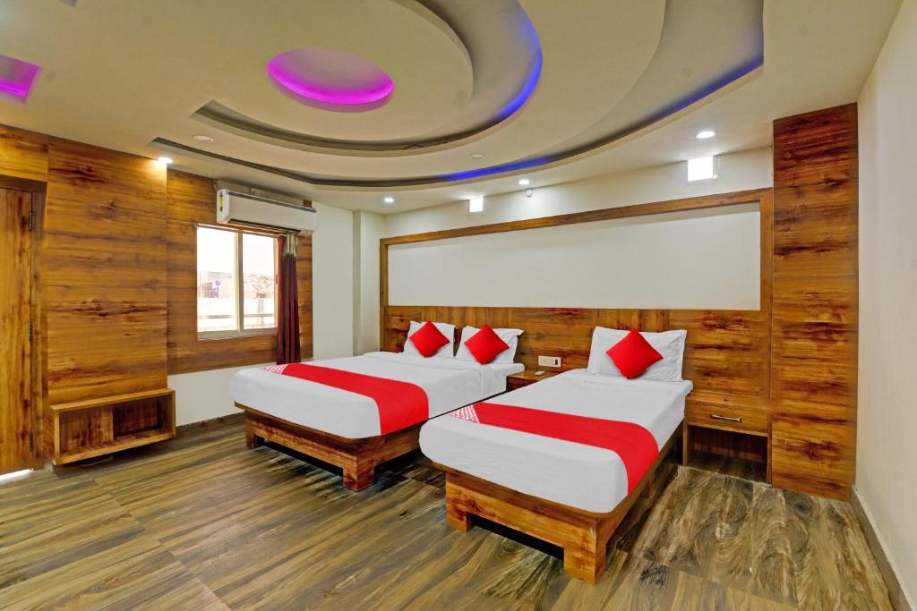 two beds in a room with wood paneling at Oxy Shivani Residency in Rānchī