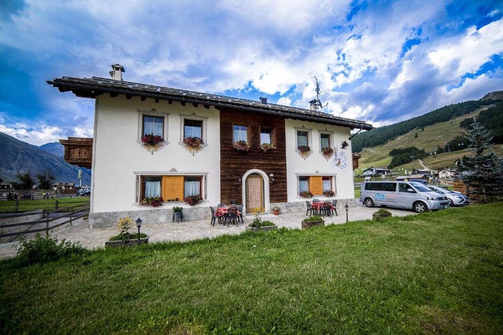 dom z samochodem zaparkowanym przed nim w obiekcie Chalet Alpine Dream w Livigno