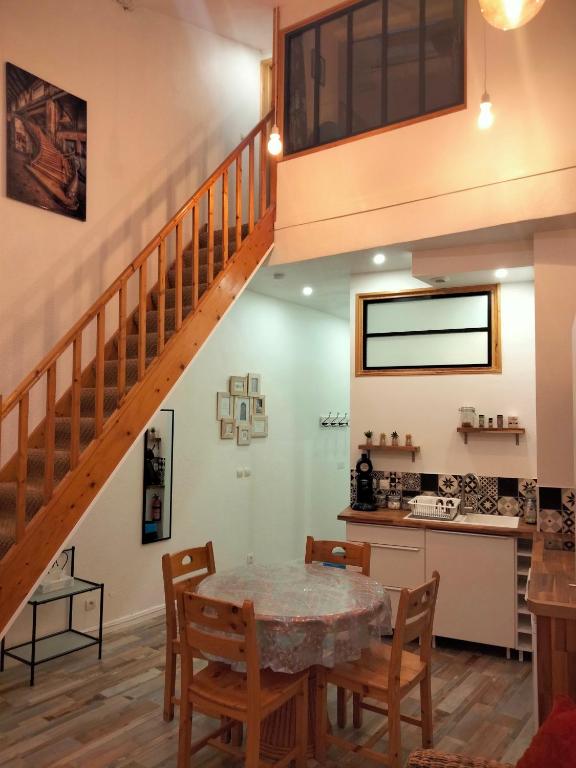 une cuisine et une salle à manger avec une table et un escalier dans l'établissement Appartement 1er étage MÈZE, à Mèze
