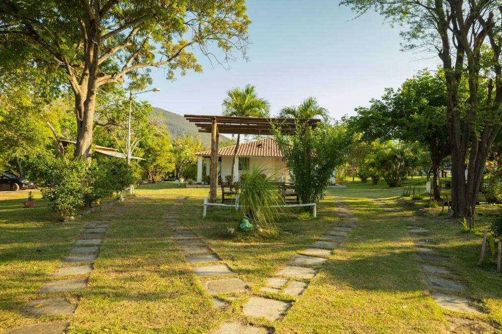 un jardín con un banco y una casa en Recanto Tauane Liz en Jequié