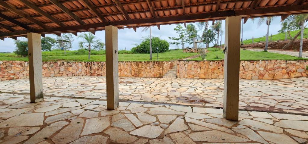 un patio de piedra con columnas y una pared de piedra en Fazenda Araras Eco Turismo - Acesso a cachoeira Araras, en Pirenópolis
