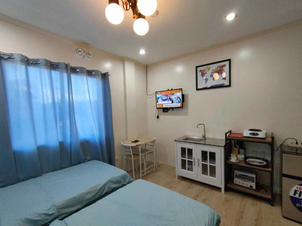 a bedroom with two beds and a tv in it at Intoy's Place in Panglao