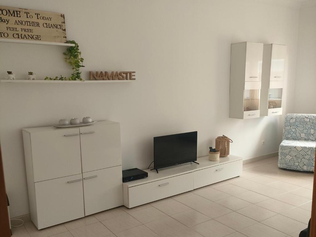 uma sala de estar com uma televisão e um armário branco em A place to rest and enjoy em Piedade