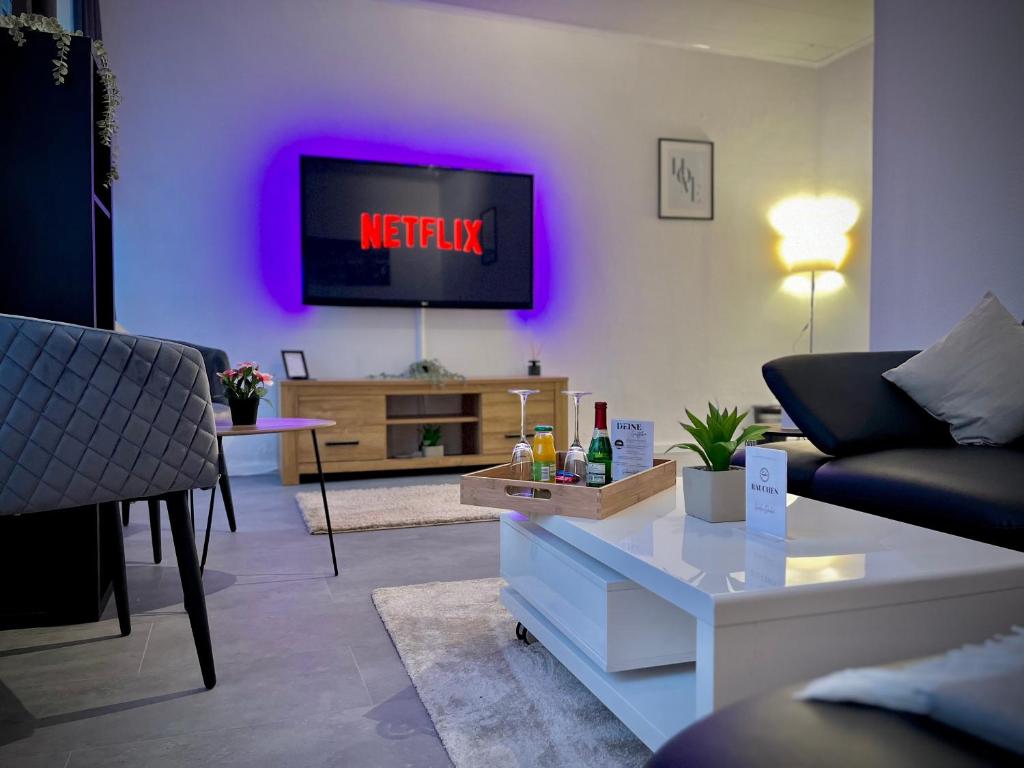 a living room with a tv on a wall at G&G Luxury Apartment am Stadtpark Bendorf in Bendorf
