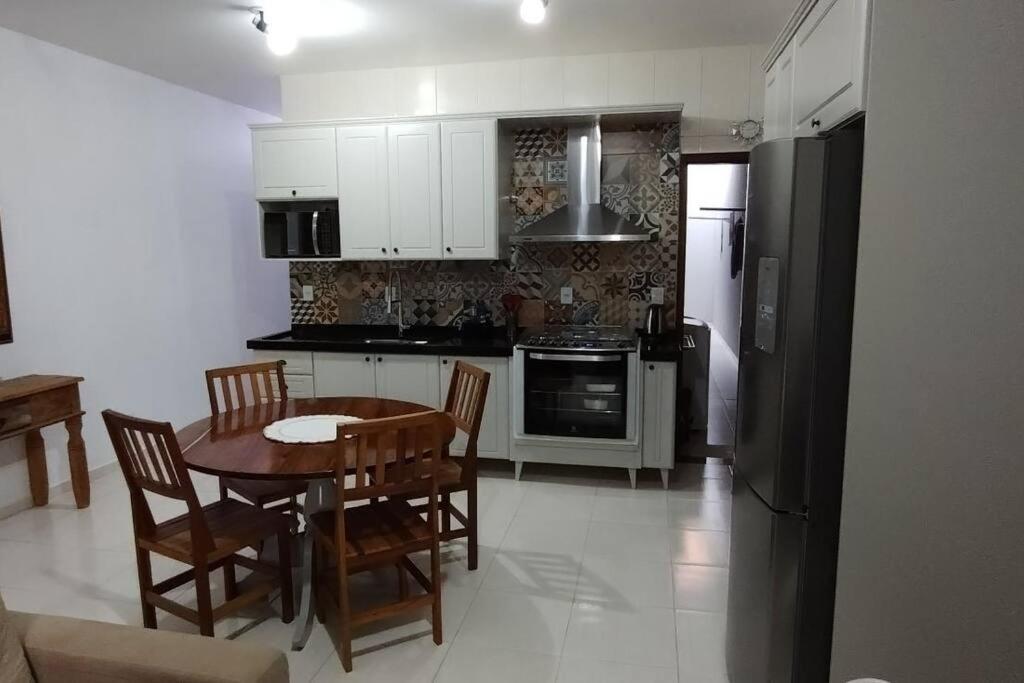 a kitchen with a table and chairs and a refrigerator at Casa aconchegante in Cascavel