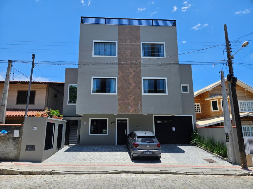 a house with a car parked in front of it at Águas de Canto Grande in Bombinhas