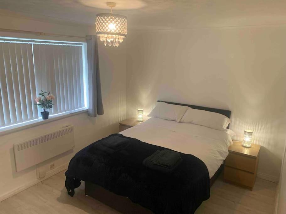 a bedroom with a bed and a window and a chandelier at Cozy flat in Birmingham with Parking in Birmingham