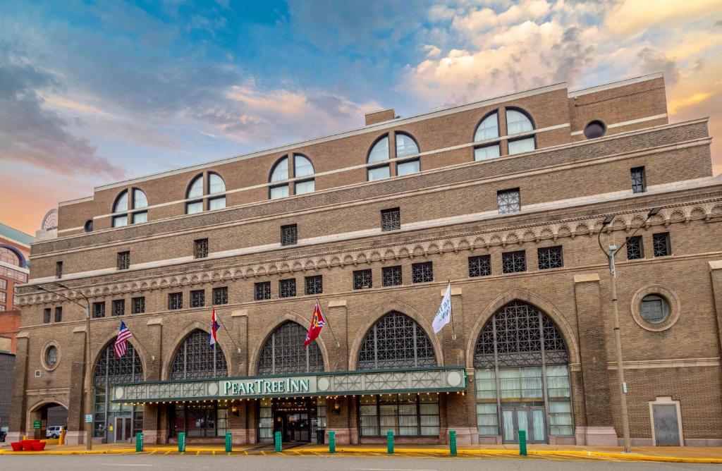 a large brick building with flags in front of it at Pear Tree Inn St Louis Convention Center in Saint Louis