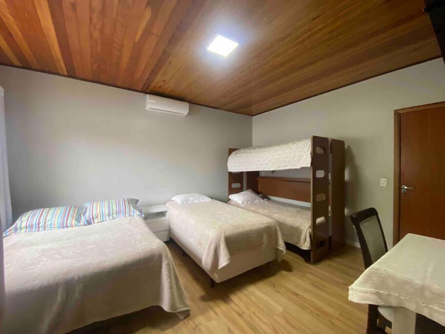 a bedroom with two beds and a bunk bed at Casa de praia aconchegante in Barra Velha