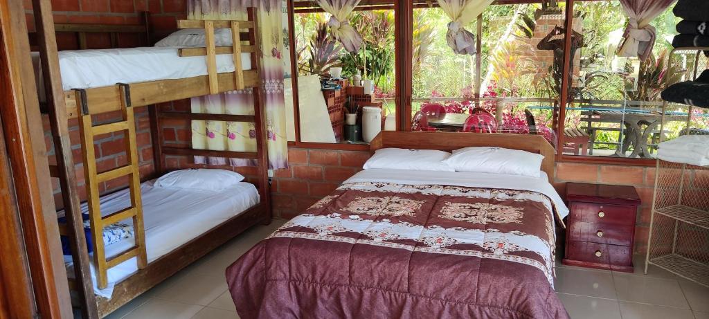 a bedroom with two bunk beds and a bed at Hostería La Tolita de John 5 Pax in Puyo