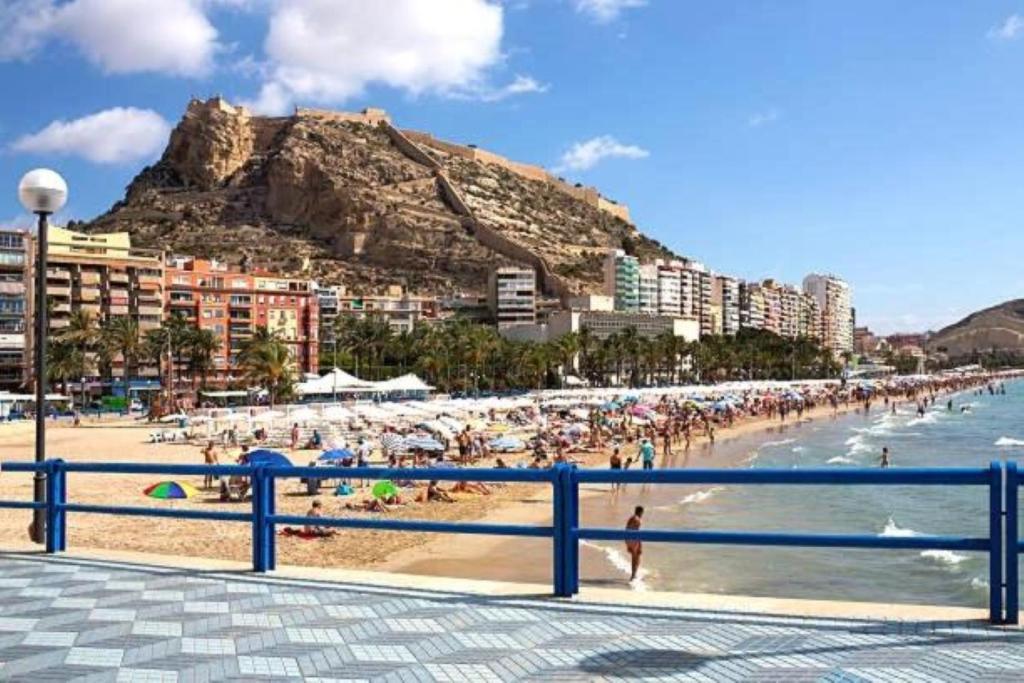 a beach with a bunch of people in the water at Modern Apartment in Alicante center Beach in Alicante