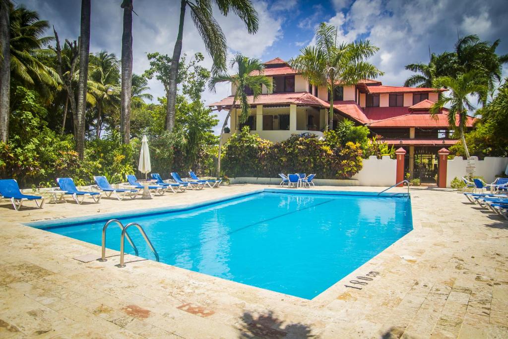 a swimming pool in front of a house at Cita del Sol City Apartments in Cabarete