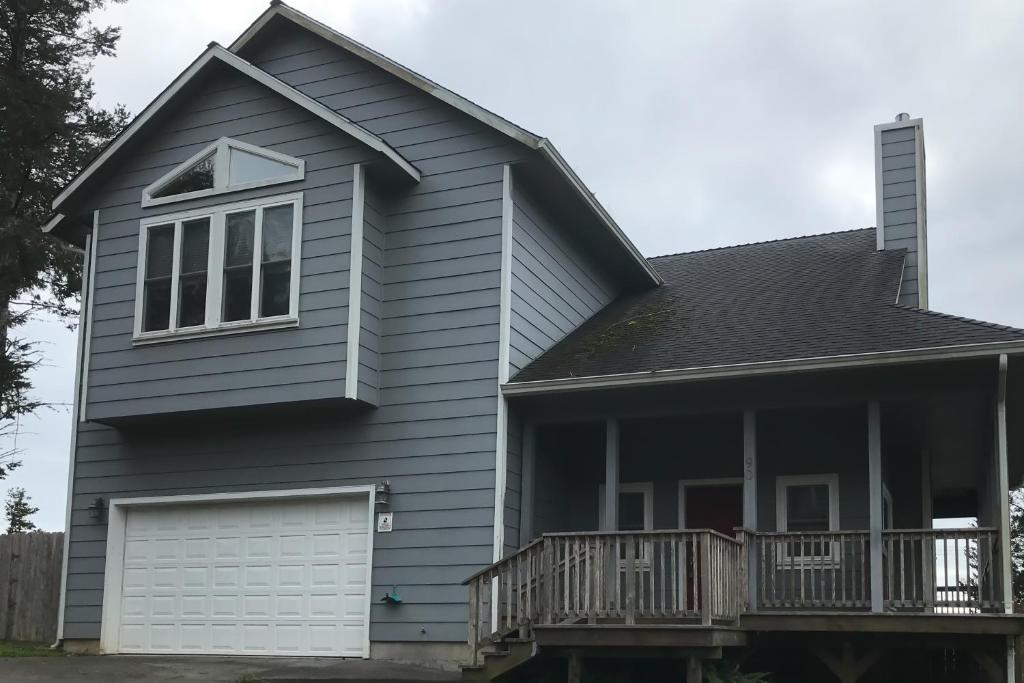 une maison avec une terrasse couverte et un garage dans l'établissement Ocean View Retreat, à Shelter Cove