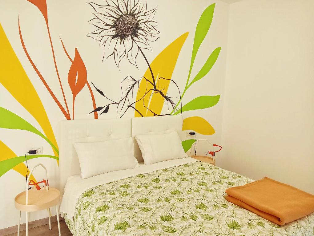 um quarto com uma cama com um mural de flores na parede em Sleep & Fly Villa Luisa em Case Nuove