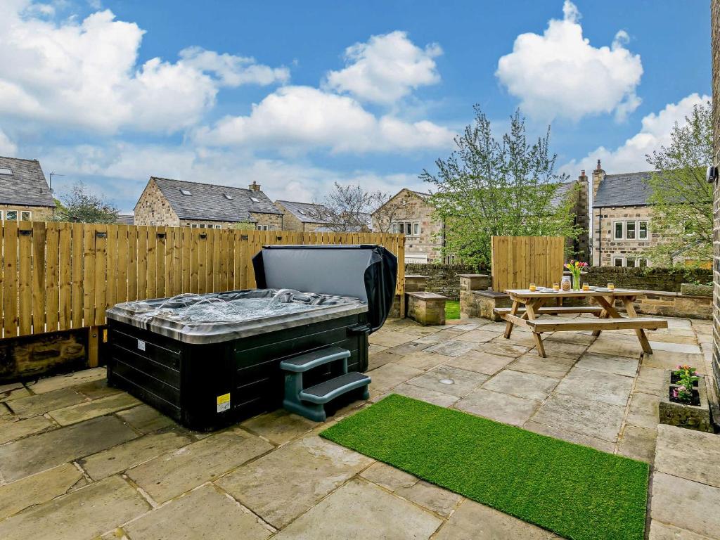 a backyard with a grill and a wooden fence at 5 Bed in Bingley 91977 in Bingley