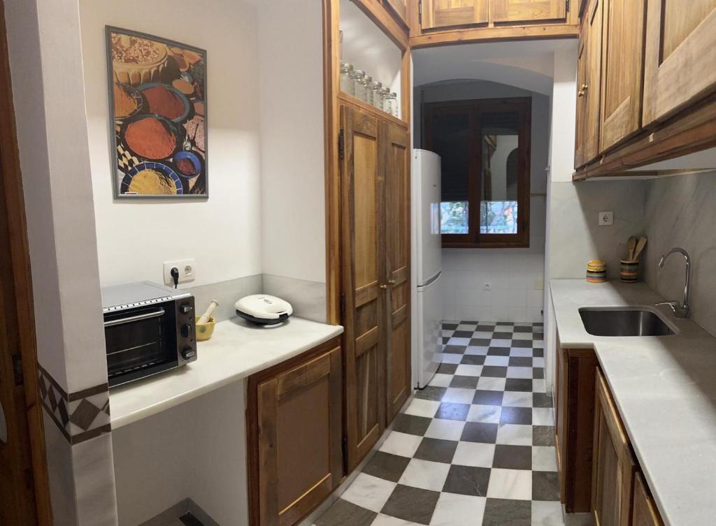 a kitchen with a black and white checkered floor at Casa Cervantes in Granada