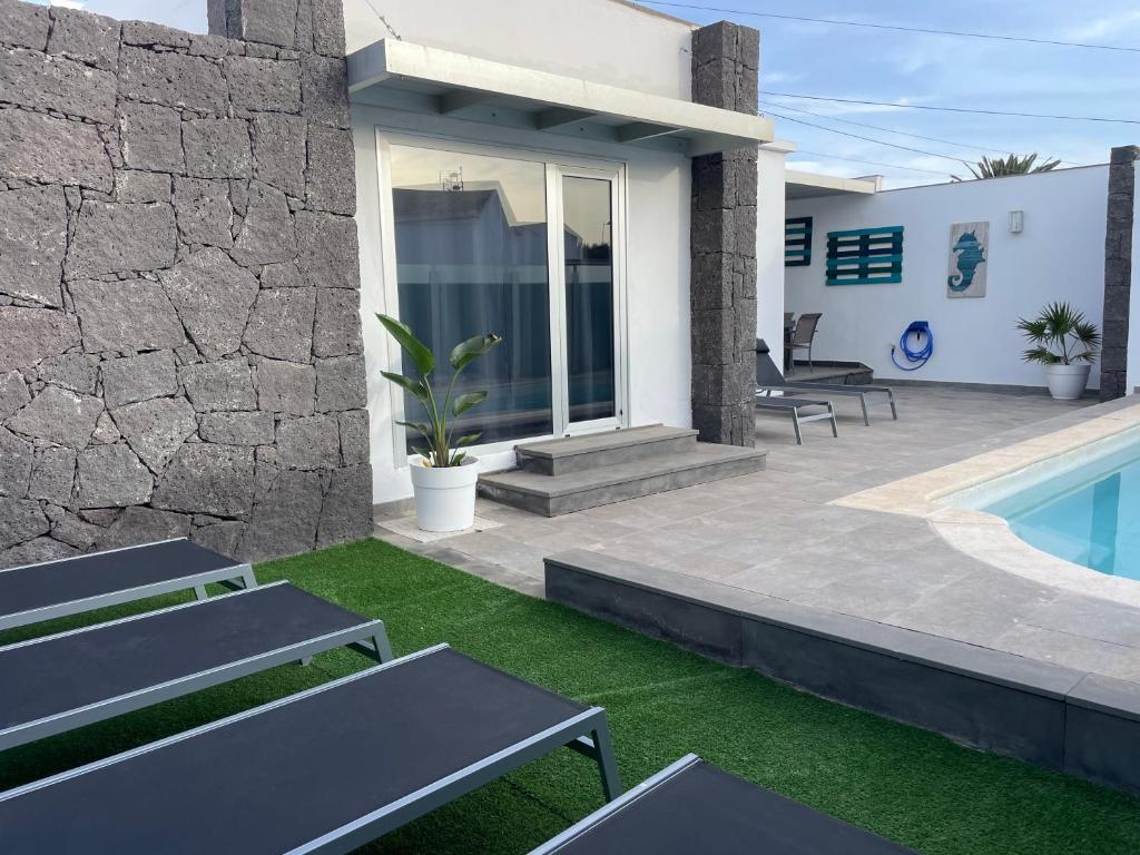 a patio with benches and a swimming pool at Villa Grey in Tahiche