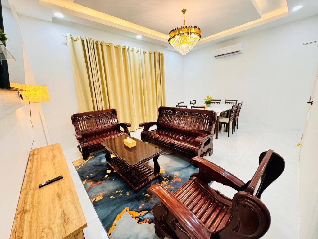- un salon avec des fauteuils en cuir et une table dans l'établissement MHI Homestay Bandar Baru Jelawat, à Bachok