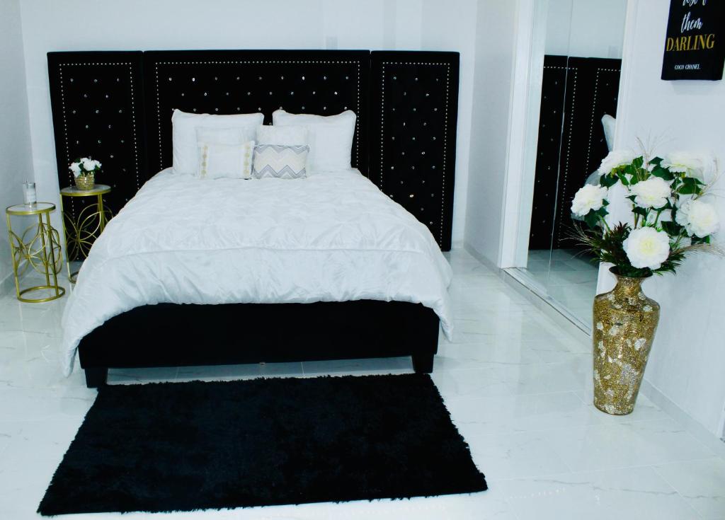 um quarto com uma cama e um vaso de flores em Luxury Studio only 5 miles to IAH em Humble