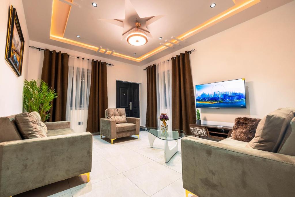 Il comprend un salon avec des canapés et une télévision à écran plat. dans l'établissement Luxury 2-Bedroom Apt at Achimota, à Taifa