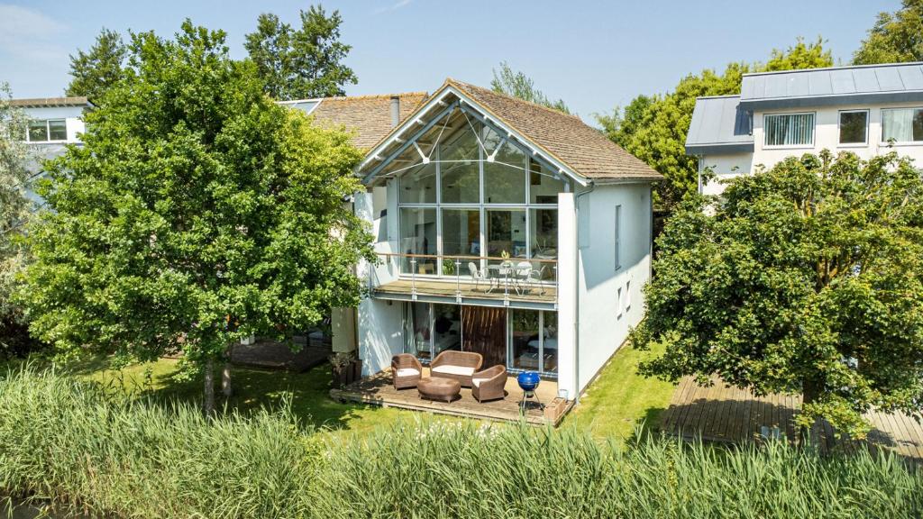 an image of a house with a conservatory at Lakeside property with spa access on a nature reserve Kingfisher Lodge CW80 in Somerford Keynes
