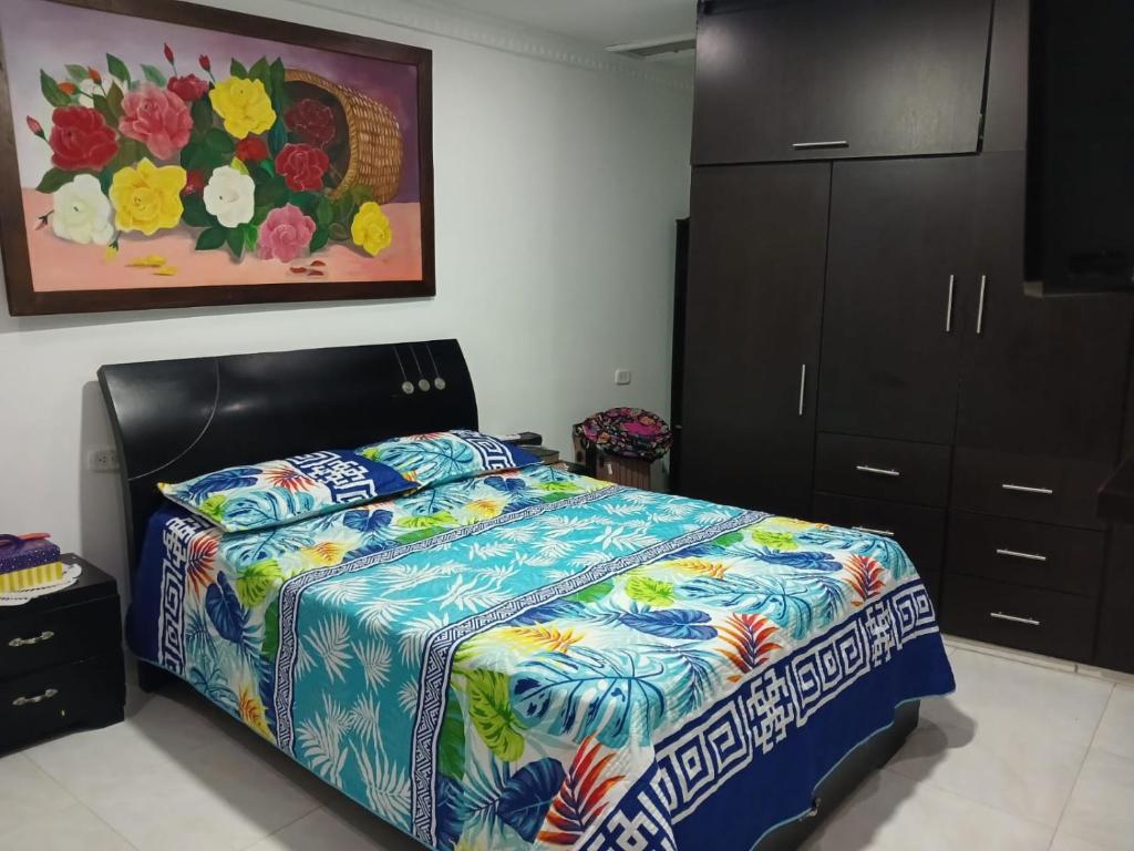 een slaapkamer met een bed met een kleurrijk dekbed bij Alojamiento festival vallenato in Valledupar