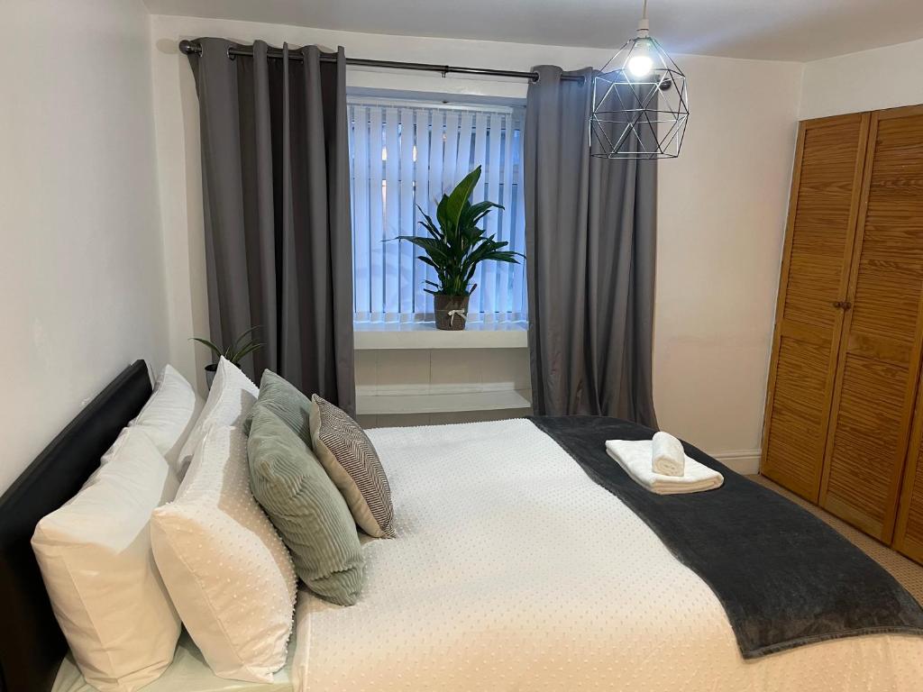 a bedroom with a bed with pillows and a window at A lovely one bed flat in North Finchley in Finchley
