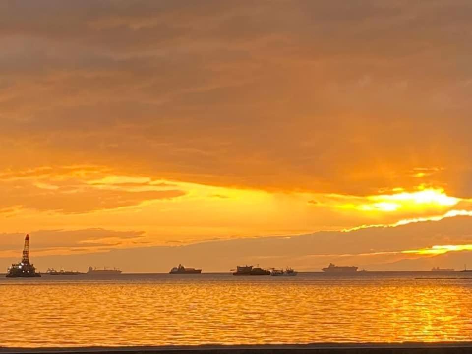 einen Sonnenuntergang über einem Wasserkörper mit Schiffen in der Unterkunft Admiral Baysuites Manila in Manila