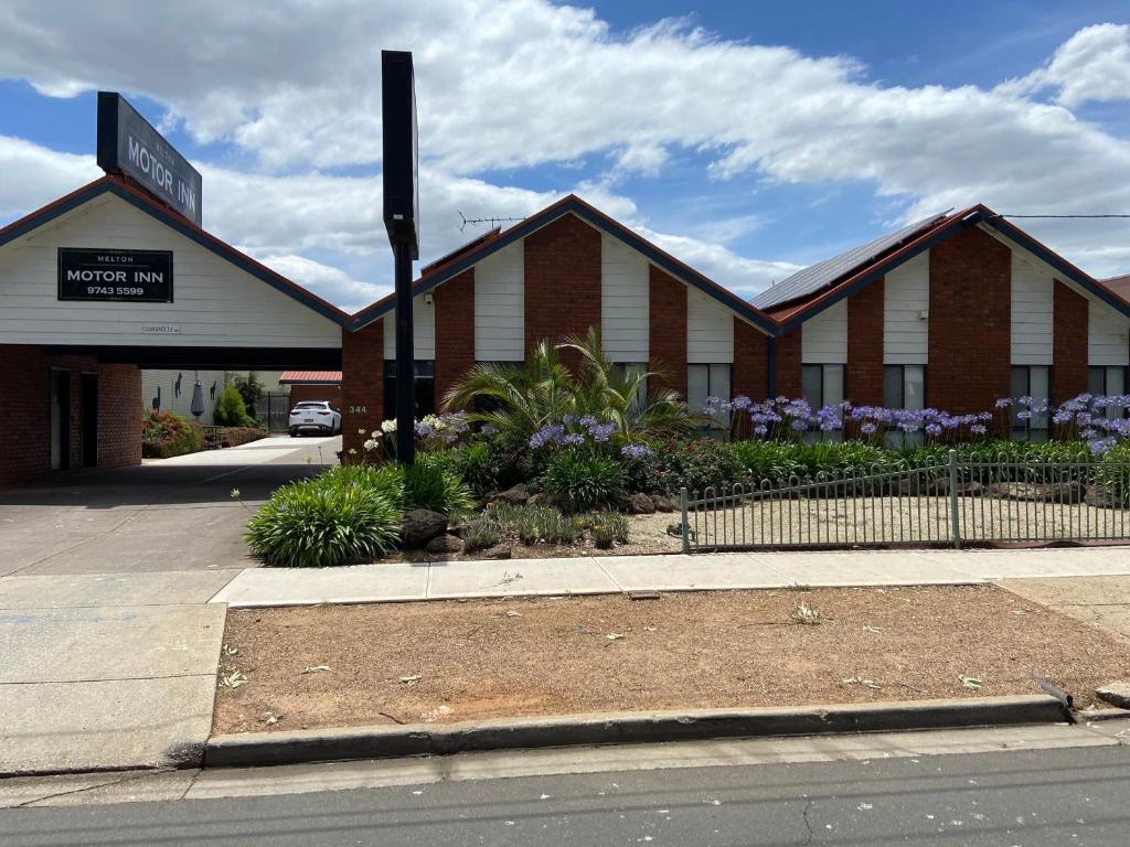 un edificio con un letrero de la calle delante de él en Melton Motor Inn and Apartments, en Melton