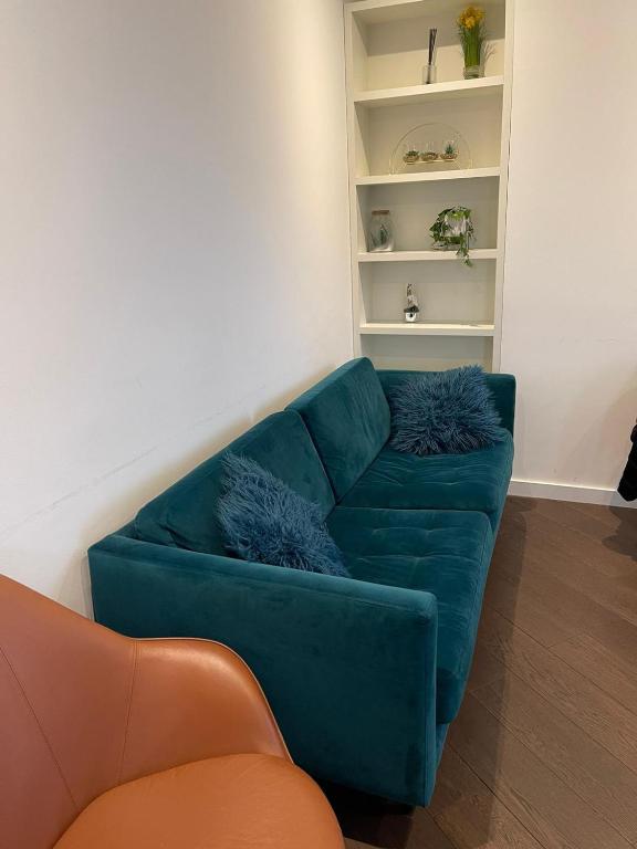 a living room with a blue couch and a shelf at Laurel Point in London