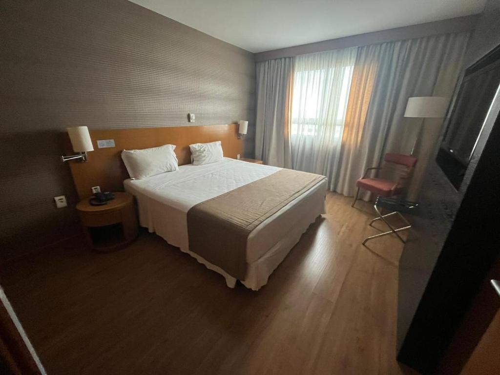 - une chambre avec un grand lit dans une chambre d'hôtel dans l'établissement Hóspede-já Brasil21 particular 203, à Brasilia