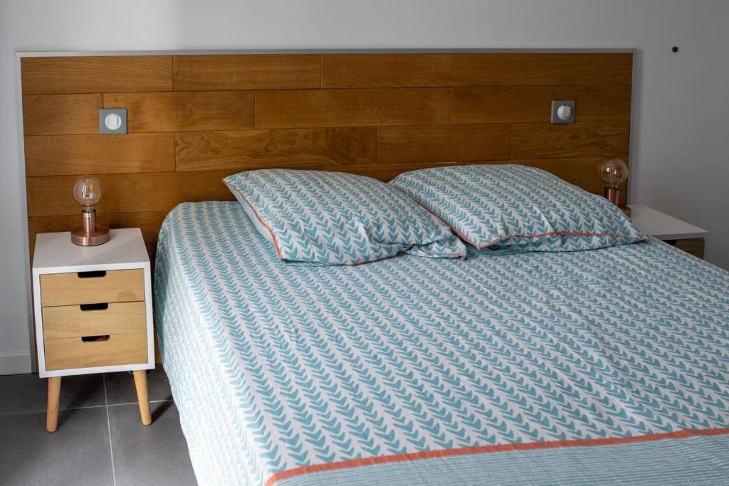 a bed with a wooden headboard and two pillows at Appartement d&#39;une chambre avec terrasse et wifi a Furiani a 3 km de la plage in Furiani