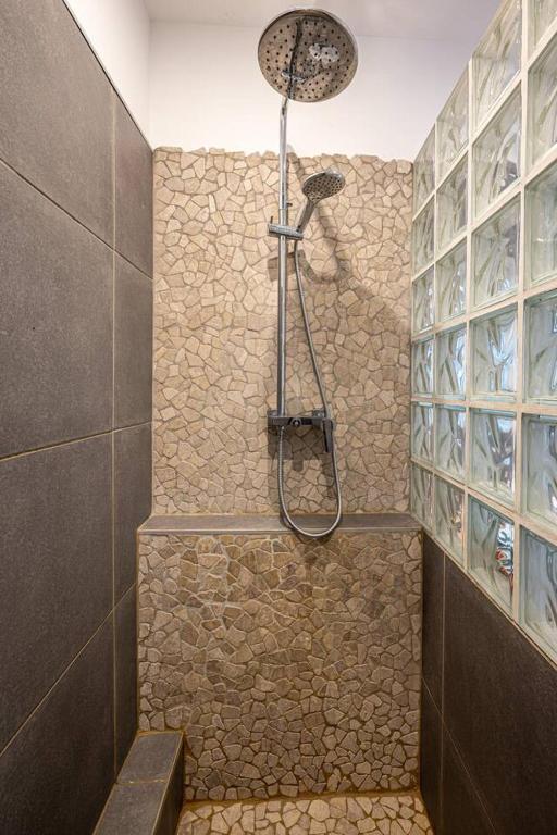 a bathroom with a shower with a stone wall at Appartement d&#39;une chambre avec terrasse et wifi a Furiani a 3 km de la plage in Furiani