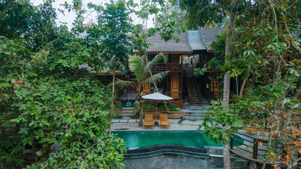 a house with a swimming pool in front of it at Tegal Campuhan Retreats in Munggu
