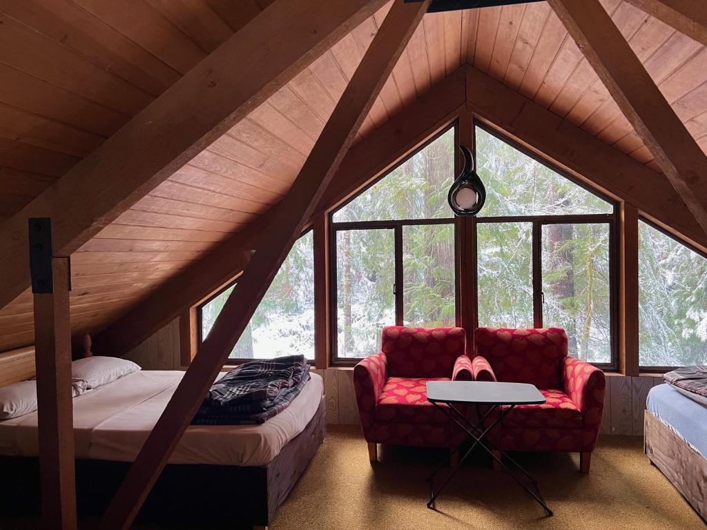 a room with two beds and a red chair in a attic at Chalet at Rainier Lodge (0.4 miles from the entrance) in Ashford