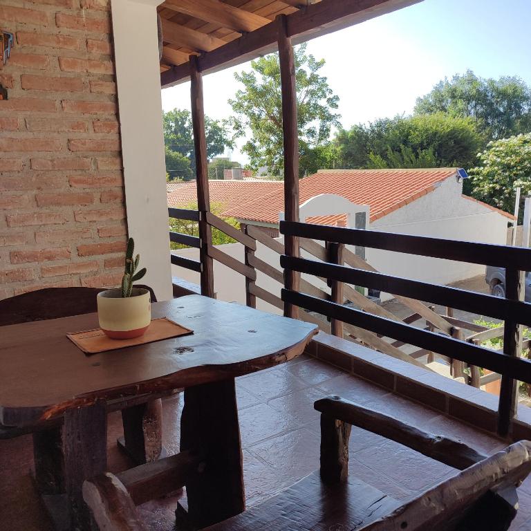a wooden table on a porch with a potted plant on it at Luna y Cumbres in Cafayate