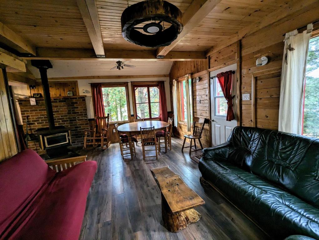 een woonkamer met een bank en een tafel bij Chalet Le Rustik du lac Castor in Saint-Paulin