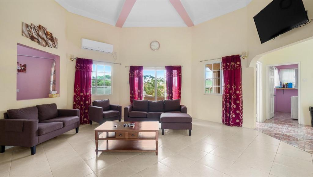 a living room with couches and a coffee table at Your roomy comfortable place K4 in Morne Rouge