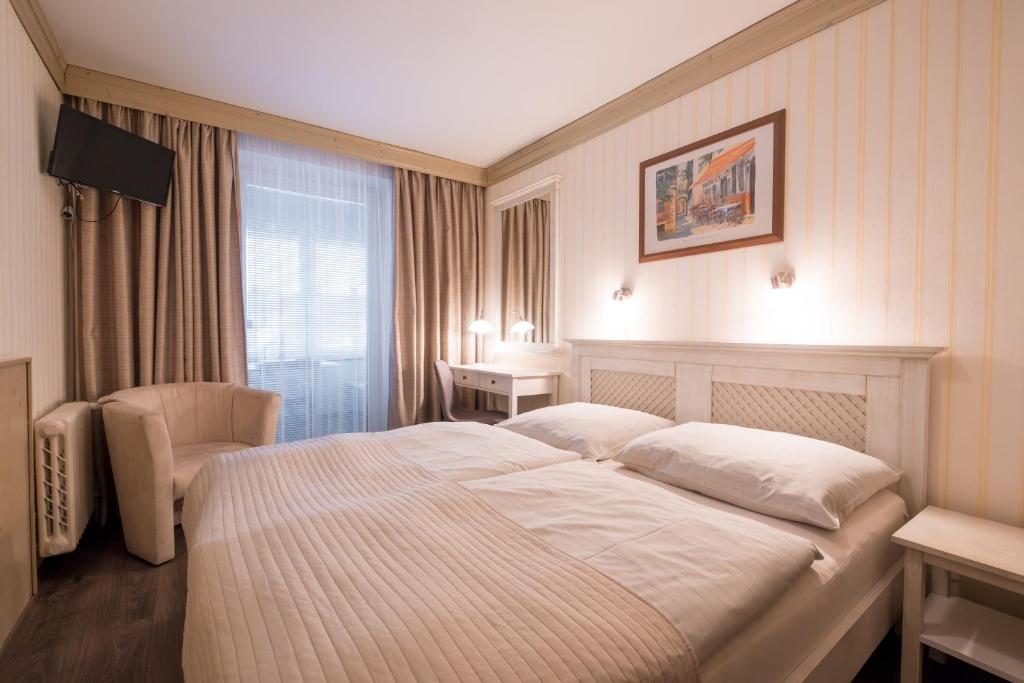 Postel nebo postele na pokoji v ubytování Hotel Maxant