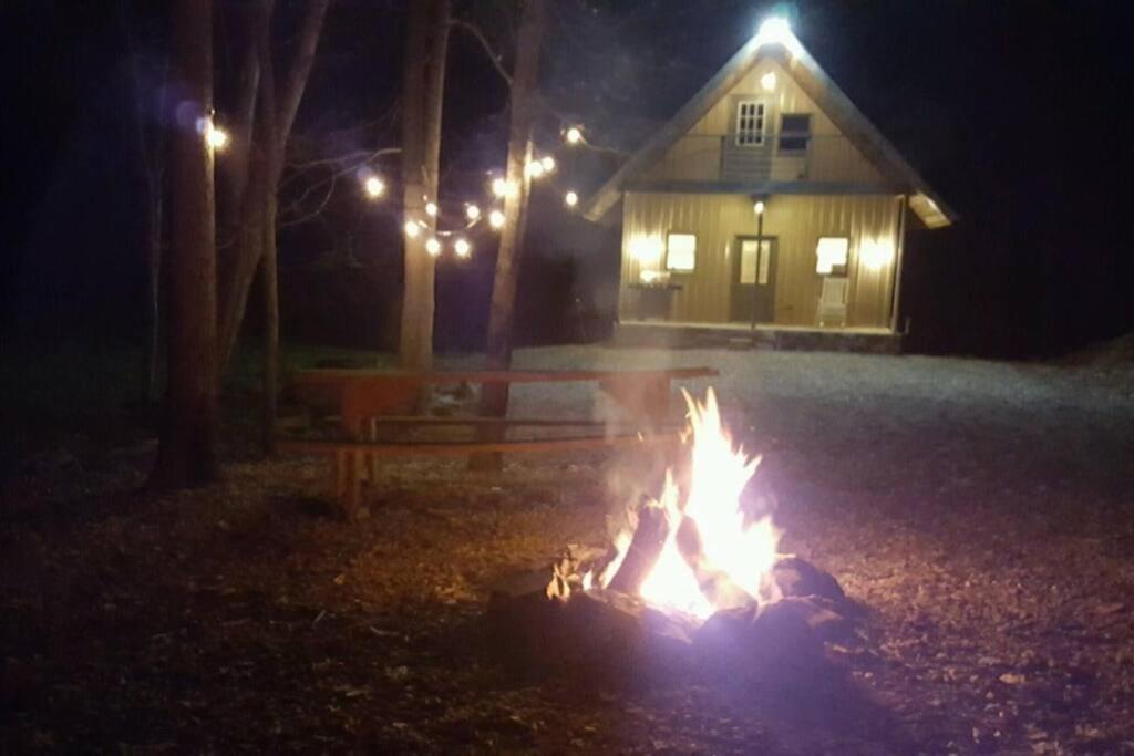 a fire pit in front of a house at night at Mohican area secluded 2 bedroom cabin in Loudonville