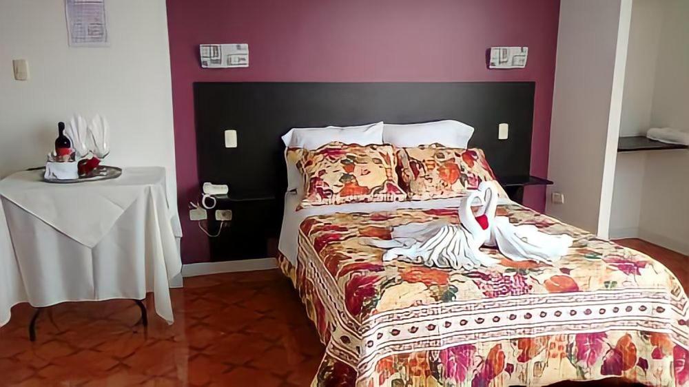 Un dormitorio con una cama y una mesa con una mesa blanca. en HOTEL CASA REAL en Tacna