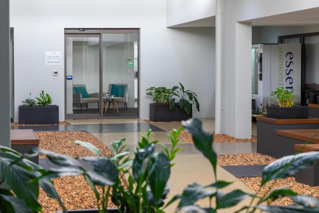 a lobby with tables and potted plants in a building at Essence Apartments Chermside in Brisbane