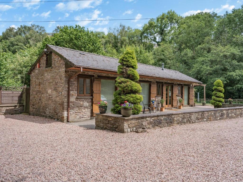 a small stone house with a stone wall at 2 Bed in Abergavenny BN187 in Clydach