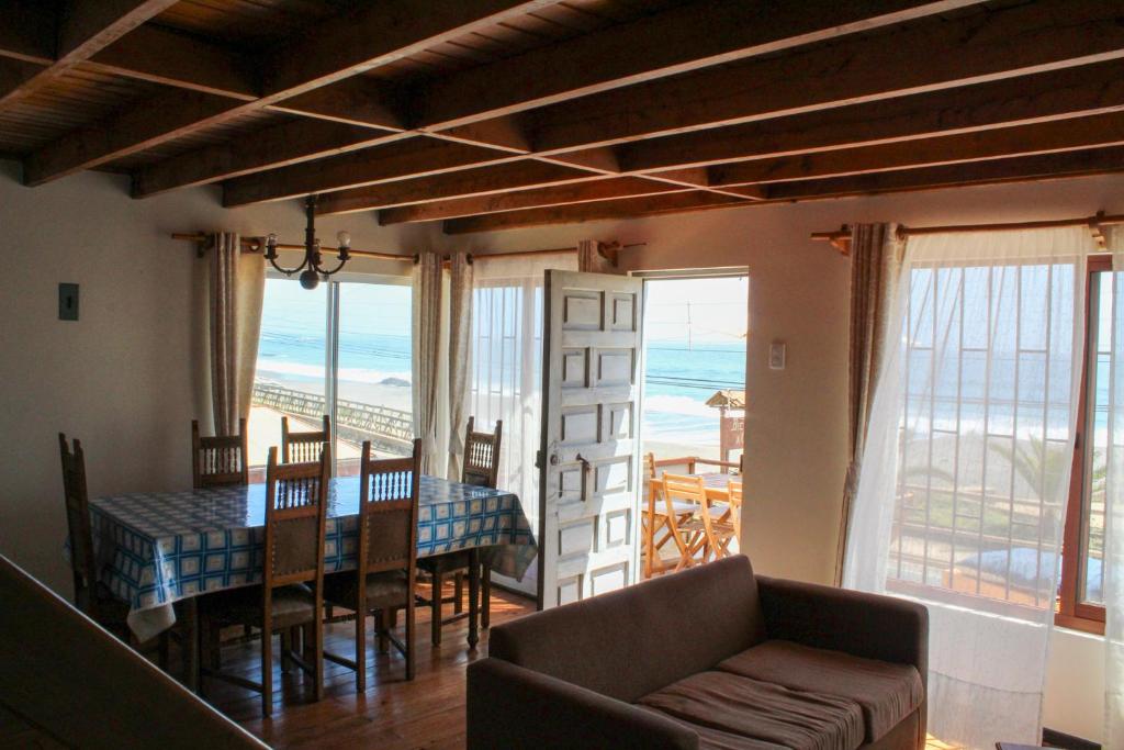 een eetkamer met een tafel en uitzicht op de oceaan bij Puesta del Sol in Pelluhue