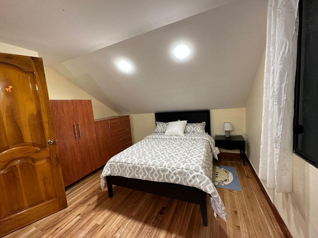 1 dormitorio pequeño con 1 cama y suelo de madera en Villa_angelita, 