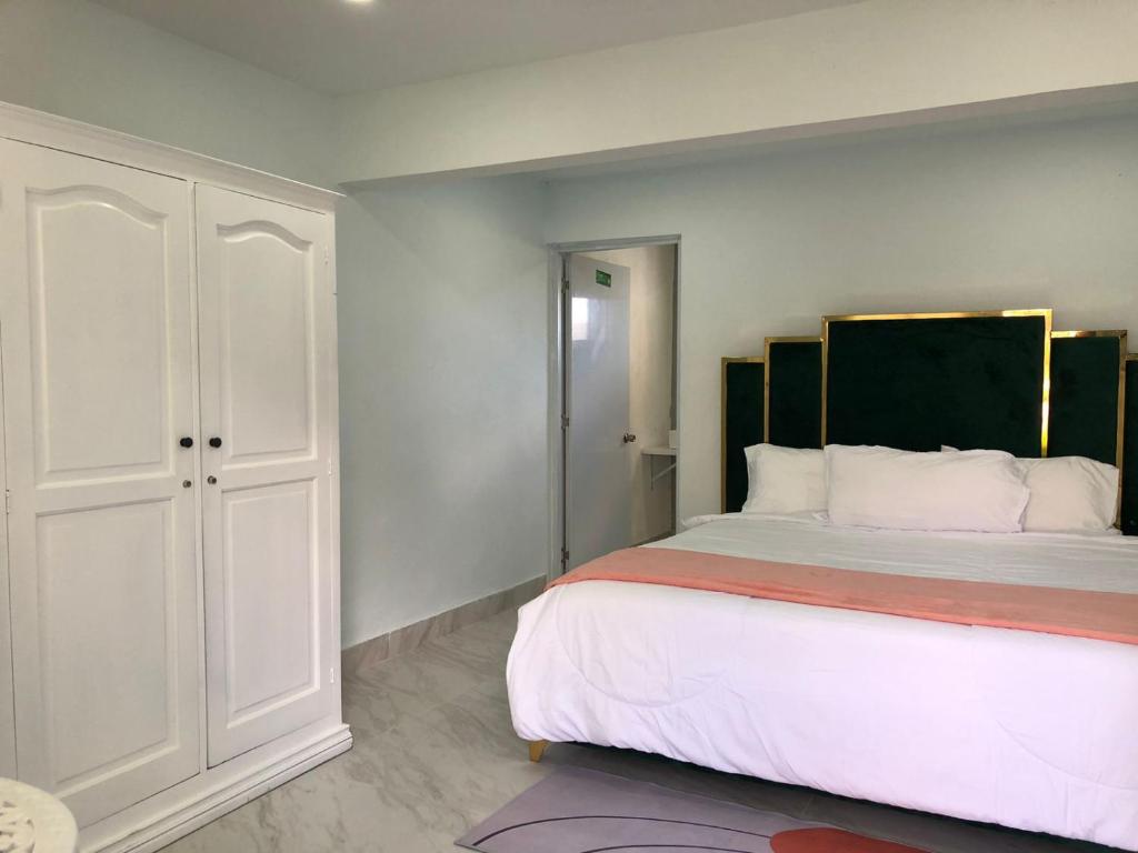 a bedroom with a large bed and a white cabinet at Garden Hotel in Cuevas