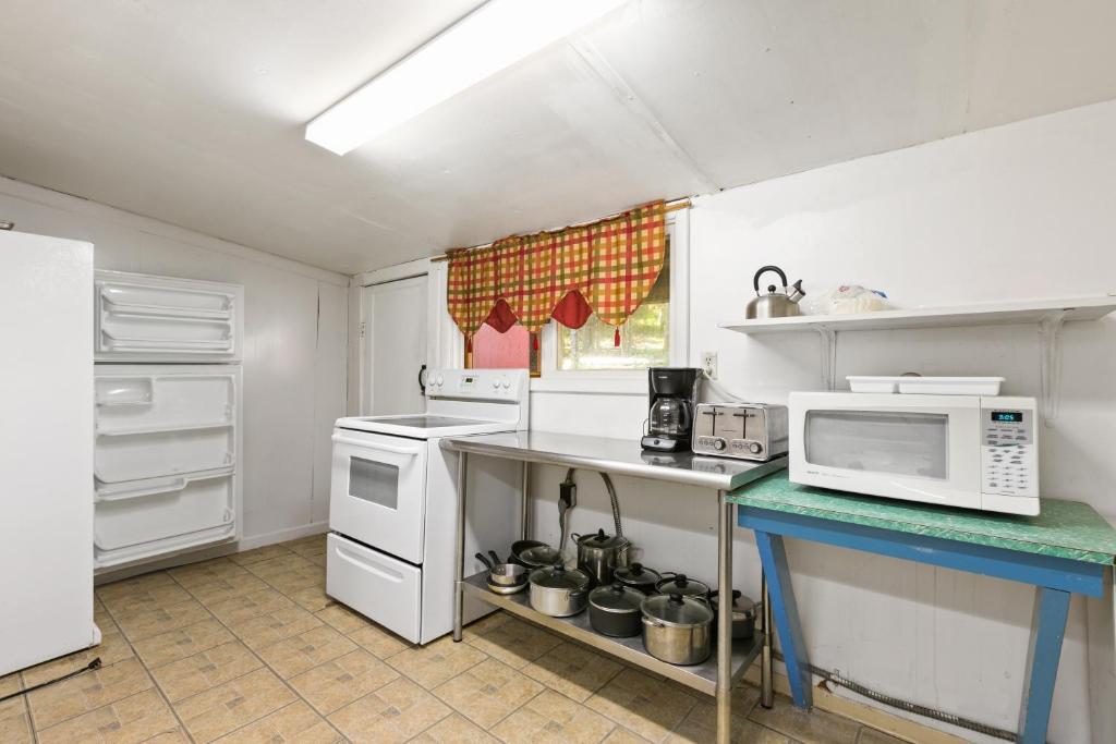 a kitchen with white appliances and a microwave at Front Lodge at Rainier Lodge (0.4 miles from entrance) in Ashford